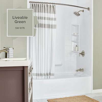 A sea foam green bathroom with the focus on a white bathtub